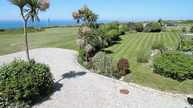 A well-maintained garden with a gravel path, various shrubs, and a lawn. - 2 bedroom accommodation in Pendeen (Pendeen)