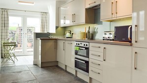 A modern kitchen with a built-in oven, a microwave, and a toaster. There is a window with curtains and a view of the outside. - 3 bedroom accommodation in Horton in Ribblesdale, near Settle (Horton in Ribblesdale, near Settle)