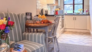 Une cuisine moderne avec des chaises à rayures, une table à manger agrémentée d’un vase de fleurs et une fenêtre offrant une belle vue.