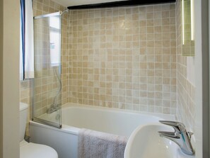 A bathroom with a bathtub, a sink, and a toilet. - Sharrowhead Cottage - E4044 (Robin Hood’s Bay)