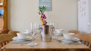 A dining table set with white bowls, wine glasses, and a silver pitcher with flowers. - 2 bedroom accommodation in Abergavenny (Abergavenny)
