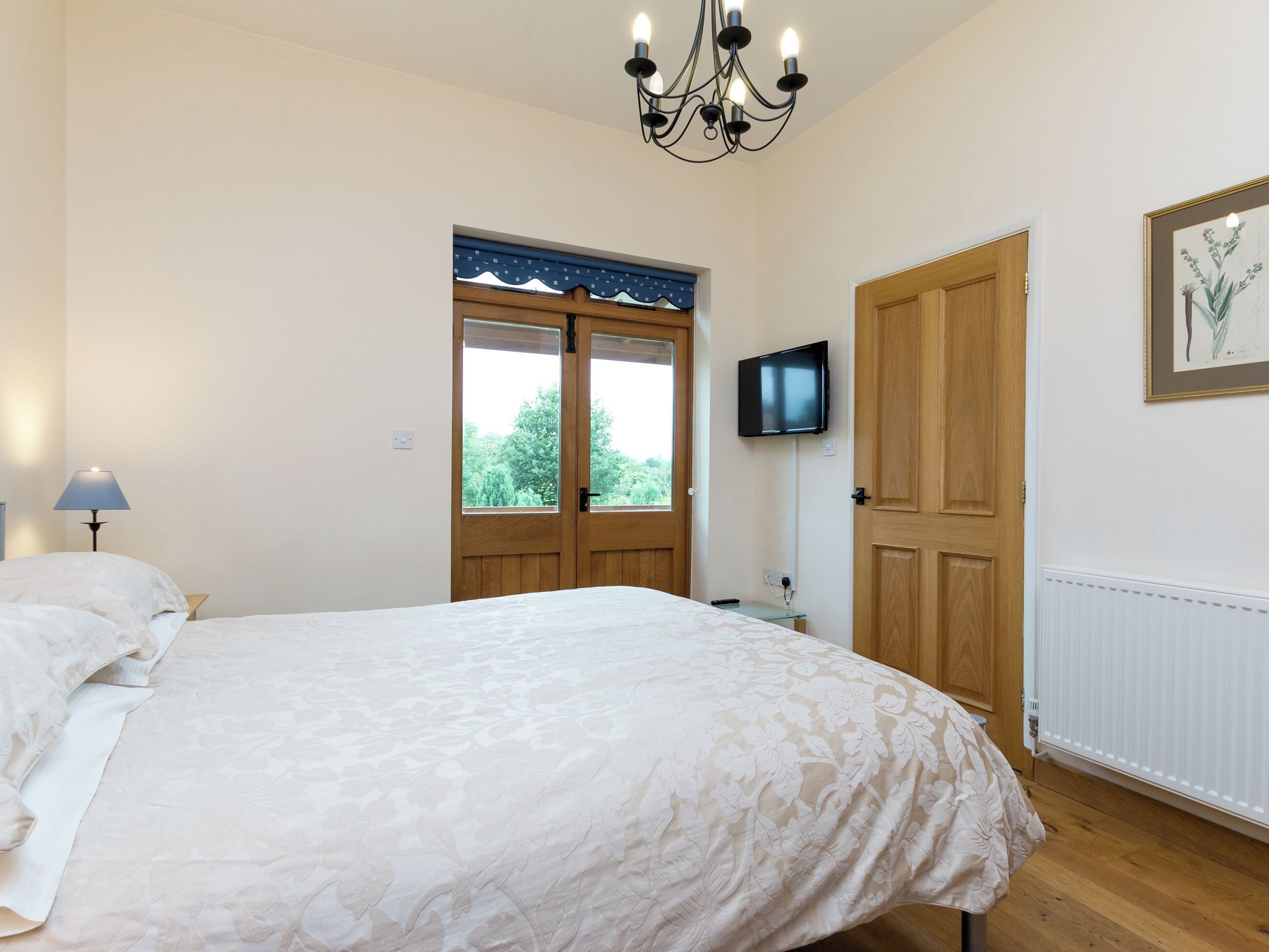 Double bedroom with wall-mounted TV | Parkers Lodge - Netherley Hall Cottages, Mathon, near Malvern