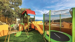 A playground with a slide, swings, and a trampoline. - Awesome home in Vinisce (Vinisce)