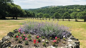 Un giardino ricco di fiori con vista sulle dolci colline circostanti.