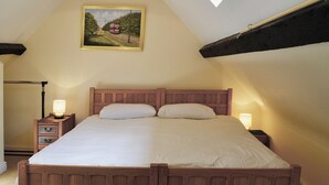 Una camera da letto con un letto in legno, due comodini con lampade, un quadro al muro e un lucernario.
