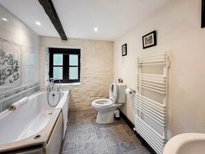 A bathroom with a bathtub, toilet, and a radiator. - 6 bedroom accommodation in Great Torrington (Great Torrington)