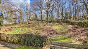 A stone staircase leading up a grassy slope with a stone wall on one side and a forested area in the background. - 3 bedroom accommodation in Beech Hill, near Bowness-on-Windermere (Beech Hill, near Bowness-on-Windermere)