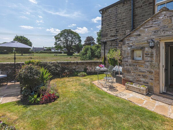 A stone building with a patio area, outdoor seating, and a view of the surrounding landscape. - 1 bedroom accommodation in Gargrave, near Skipton (Gargrave, near Skipton)