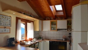 Una cocina con vigas de madera, una ventana y salpicadero de azulejos.