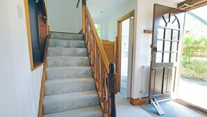 A staircase with wooden railings and carpeted steps leading to an open door. - Branscombe beach is only 1½ miles away and the Jurassic Coast is nearby. (Branscombe)