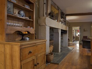 Un intérieur en bois avec une cheminée en pierre, des étagères en bois et un canapé en cuir.