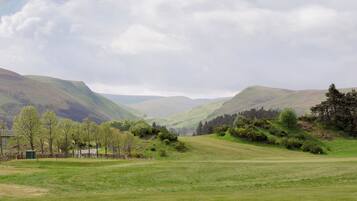 A wide, open field with rolling hills in the background.