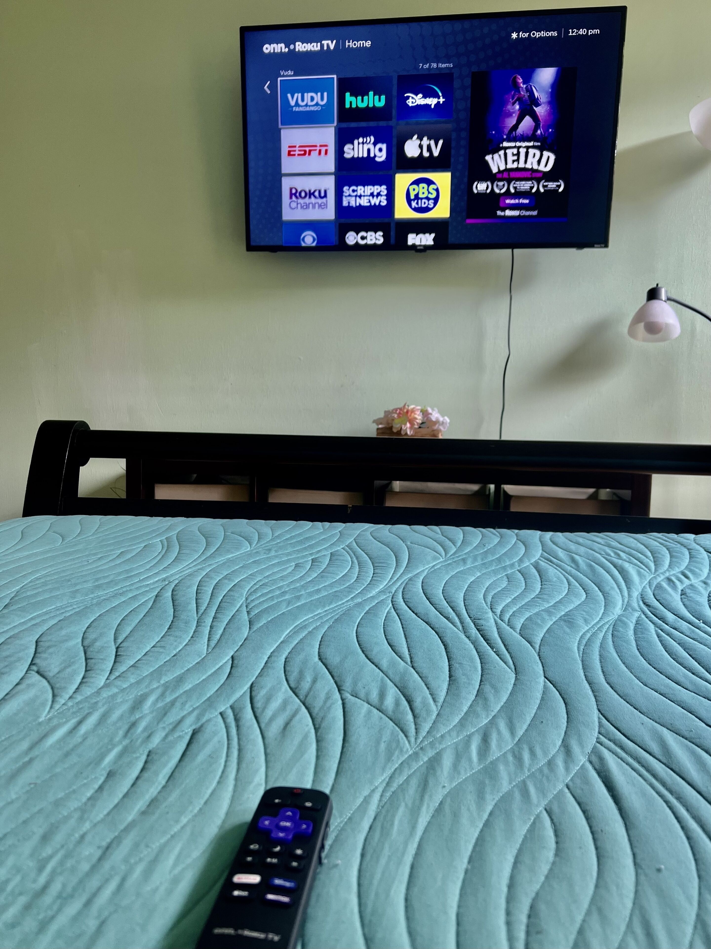 A television mounted on a wall displaying various streaming services and a movie poster.