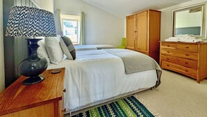 A bedroom with a bed, dresser, mirror, lamp, and a window. - 4 bedroom accommodation in Rispond, near Durness (Rispond, near Durness)