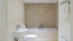 A modern bathroom with a bathtub, toilet, and sink. - 4 bedroom accommodation in Rispond, near Durness (Rispond, near Durness)