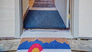 A hallway leading to a living area with a door, a rug, and a doormat. - Affordable, updated, quiet, location, location, location! (steamboat springs)