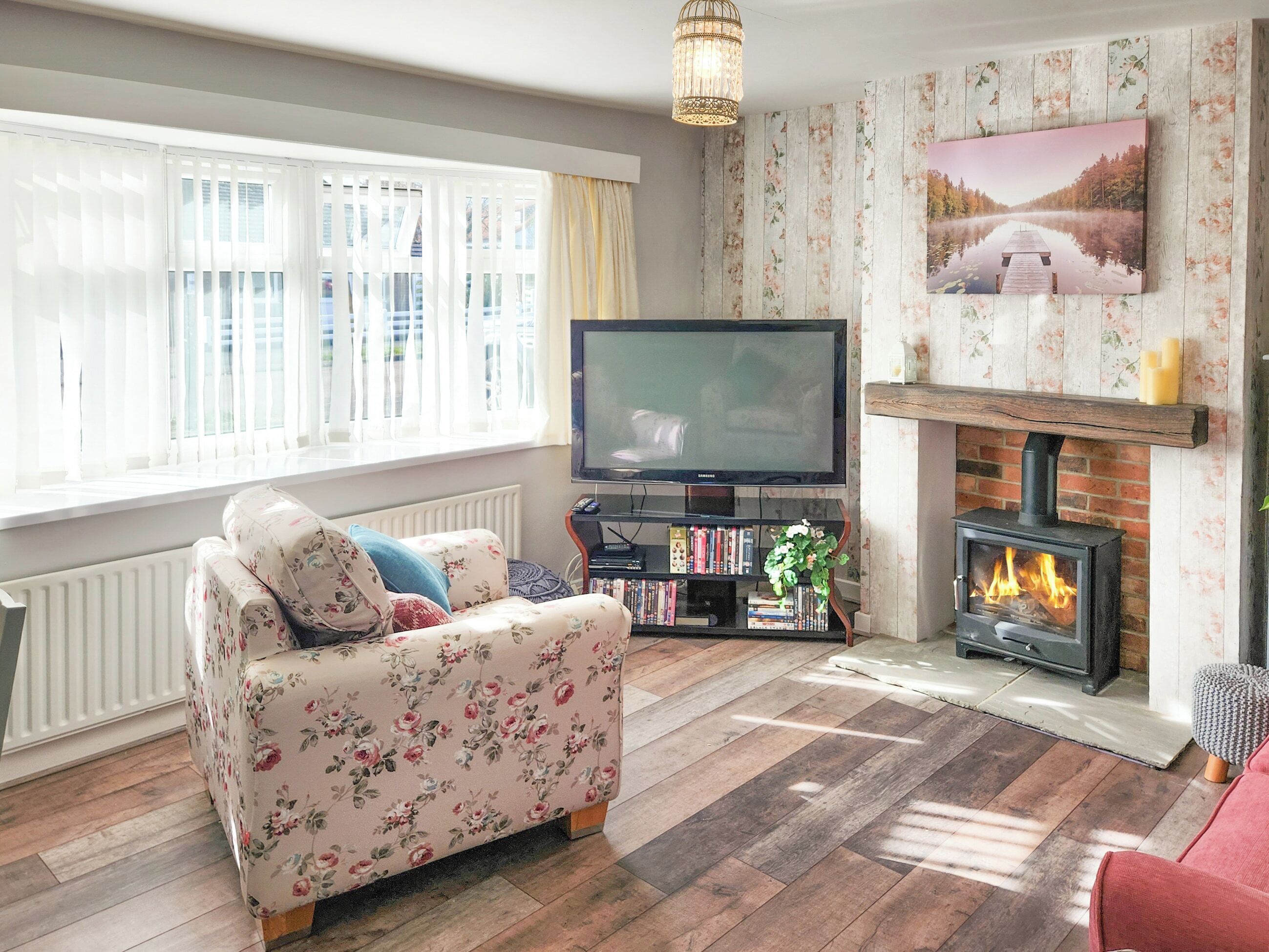 Ein Wohnzimmer mit Sofa, Fernseher, Kamin und Bücherregal.