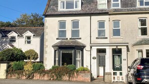 A two-story building with a traditional architectural style, featuring a central entrance with a door and a sign above it. - 2 bedroom accommodation in Bassenthwaite, near Keswick (Bassenthwaite, near Keswick)