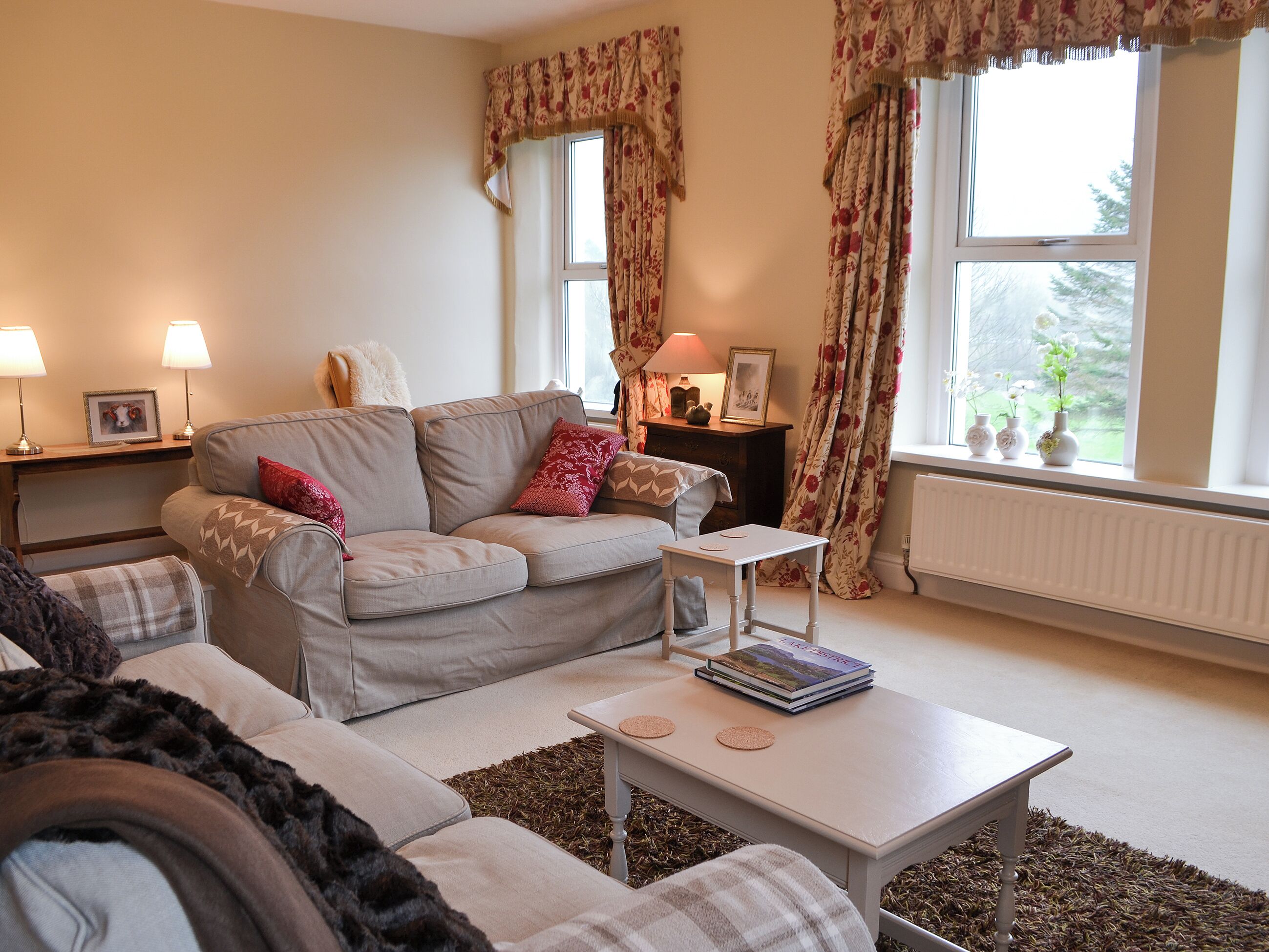 A cozy living room with a sofa, a coffee table, and a side table with lamps.