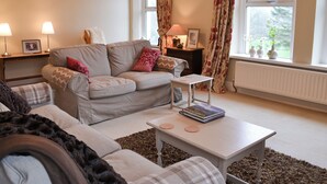 A cozy living room with a sofa, a coffee table, and a side table with lamps. - 2 bedroom accommodation in Bassenthwaite, near Keswick (Bassenthwaite, near Keswick)