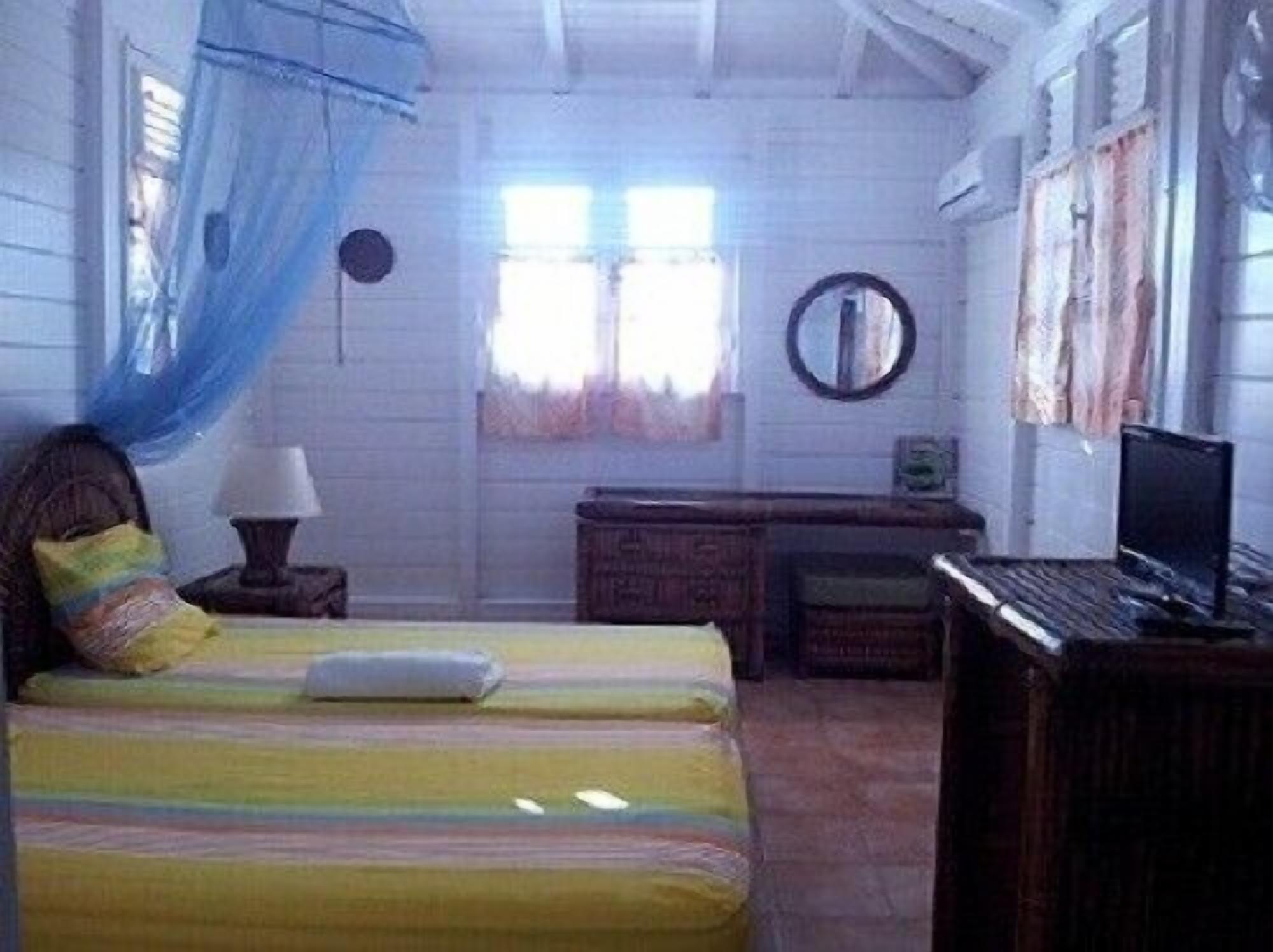Un dormitorio con dos camas, un tocador, un escritorio y un televisor.