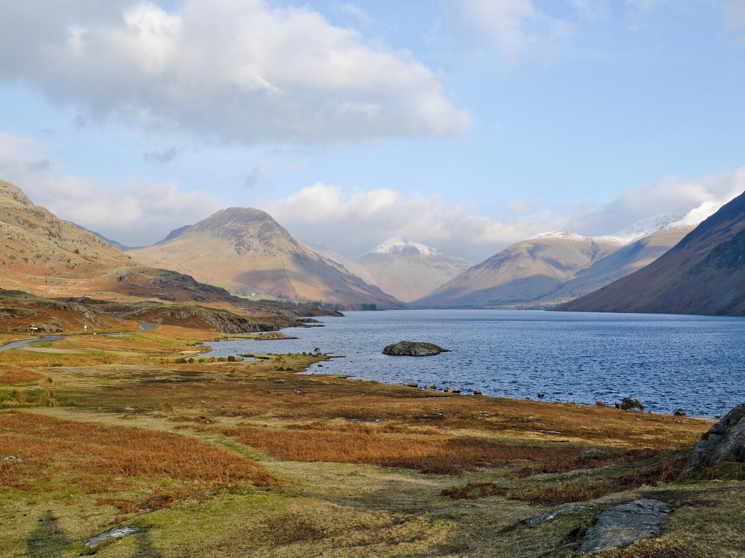 A mountainous landscape with a lake and a small island.
