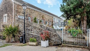 A stone building with a traditional design, a paved entrance, and a metal gate. - 1 bedroom accommodation in Gowerton, Gower (Gowerton, Gower)