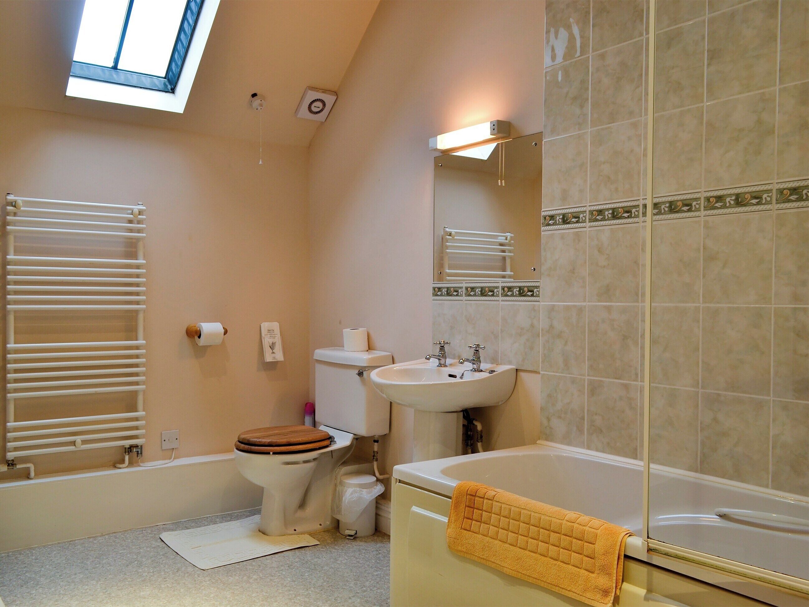 A bathroom with a toilet, sink, and bathtub.