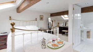 A bedroom with a bed, bedside table, and a breakfast tray with croissants and eggs. - 3 bedroom accommodation in Bradwell (Bradwell)