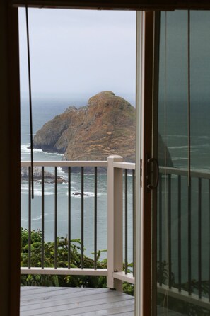 A view from a balcony overlooking a rocky coastline with the ocean. - Oceanside View House (Oceanside)