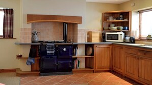 Una cucina con forno integrato, microonde ed eleganti pensili in legno.