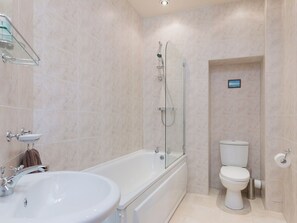 A modern bathroom with a bathtub, sink, and toilet.