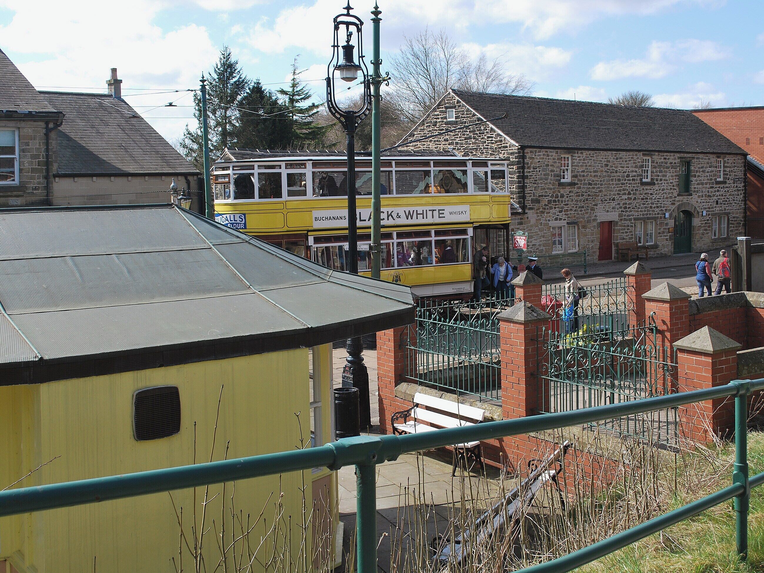A yellow building with a sign for 'Buchanans Flour' and a 'Lock & White Whisky' shop.