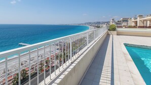 Een balkon met uitzicht op zee en een zwembad.