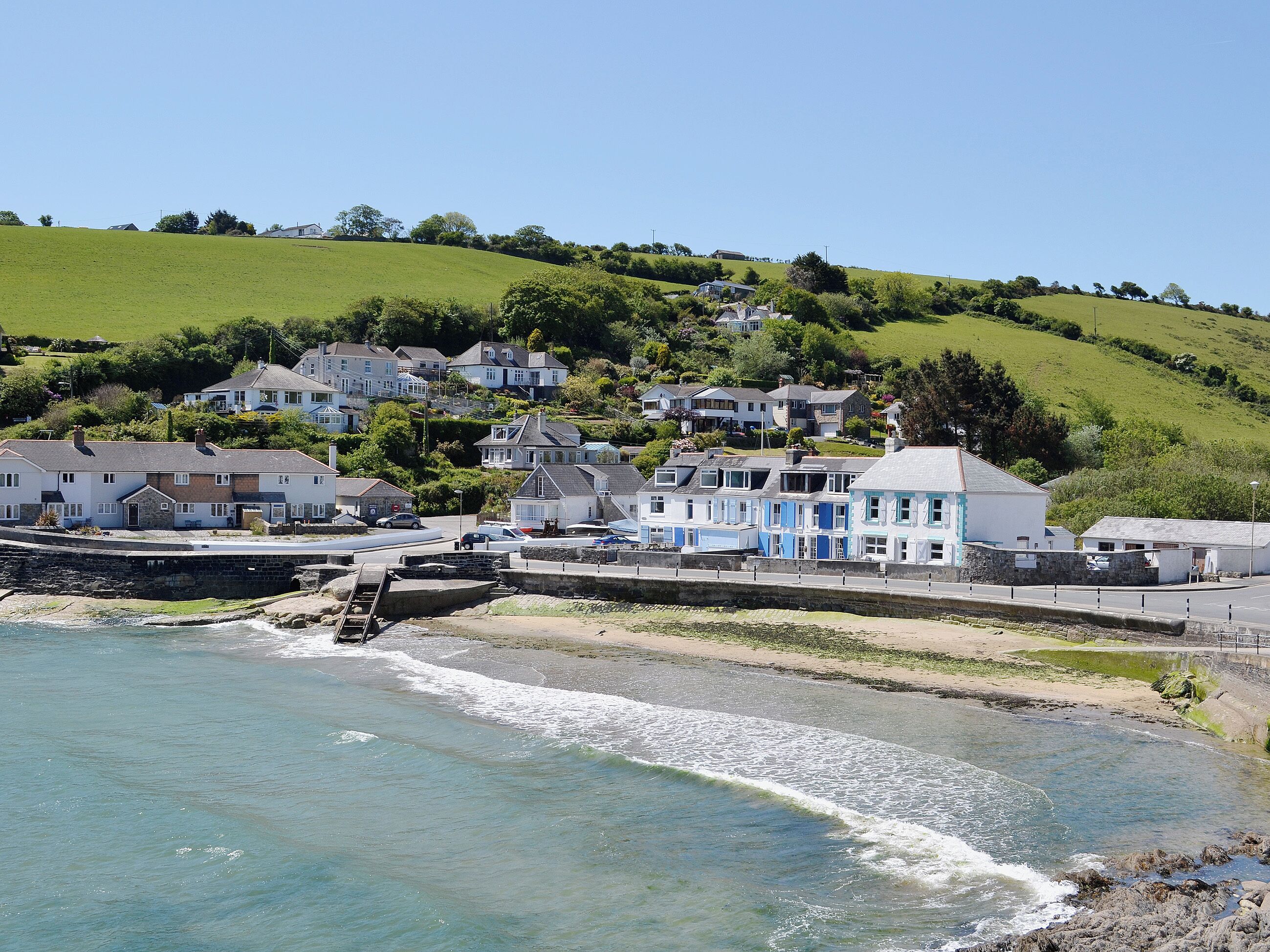 Une ville côtière avec des maisons, une jetée et une plage.