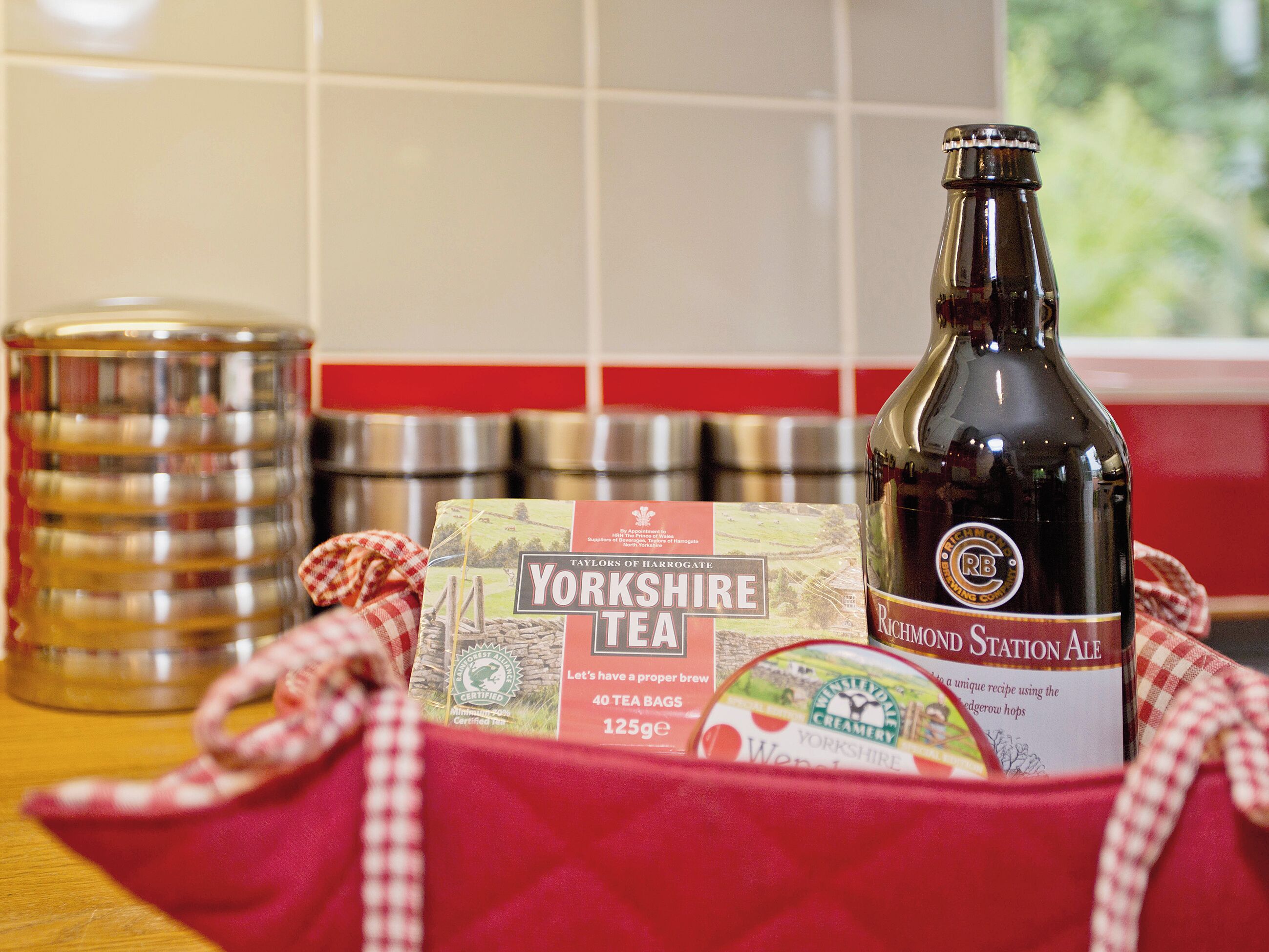 A kitchen counter with a bottle of Yorkshire Tea, a canister, and a tea bag package.