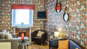 Una habitación amoblada con chimenea, televisor y una mesa de comedor con comida y bebidas.
