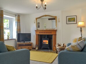 A living room with a fireplace, a television, and two sofas.