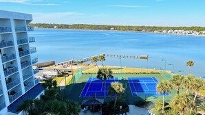 Ein Strandhotel mit Tennisplatz, Steg und Blick auf den Ozean.