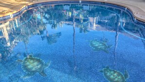 A swimming pool with mosaic tiles and three sea turtles swimming. - Spacious End Unit (Kihei)