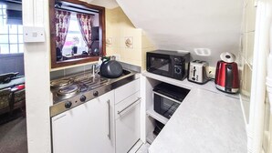 Una cocina compacta con estufa, microondas, tostadora y horno.