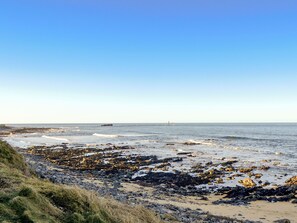 A coastal landscape with a rocky shoreline, calm sea, and clear sky. - 3 bedroom accommodation in Cairnbulg, near Fraserburgh (Cairnbulg, near Fraserburgh)