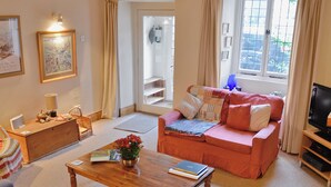 Una sala de estar con sofá, mesa de centro y televisor.
