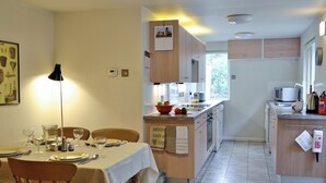 Una cocina con comedor, máquina de café y microondas.