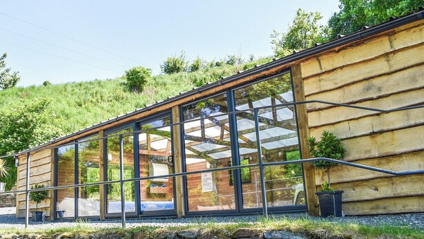 A modern building with large glass windows and a stone wall foundation. - 2 bedroom accommodation in Polbrock, Washaway (Polbrock, Washaway)