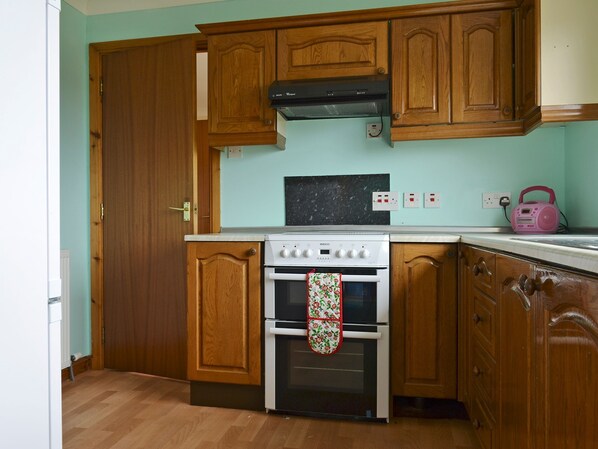 A kitchen with wooden cabinets, a stove, and an oven.