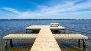Een houten steiger die zich uitstrekt in kalm water, met een heldere lucht erboven.