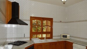 Una cocina equipada con estufa a gas, microondas, lavaplatos y lavadora.
