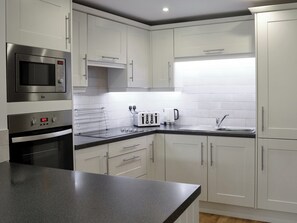 Een vaatwasser, kookgerei, borden en bestek, een vriezer