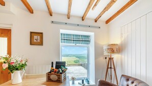 A cozy room with a wooden table, a chair, a lamp, and a view of a green landscape through a window. - 3 bedroom accommodation in Yarrow Moor, near Bellingham (Yarrow Moor, near Bellingham)